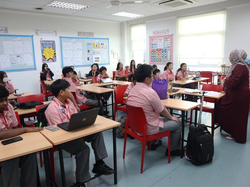 A class of Secondary School students listening to their teacher attentively during their 1st day of school