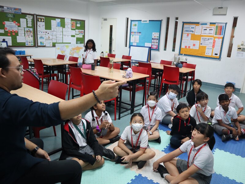 Homeroom teacher interacting with his Primary school students on the 1st day of school